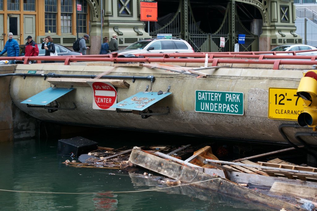 Floodwaters and floating debris all the way up to an overpass with a sign that says "Battery Park Underpass."