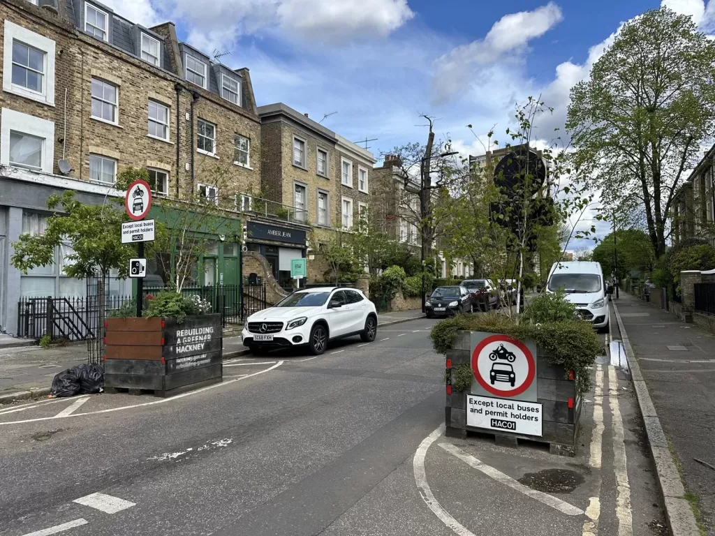 Two planters on a street block car access.