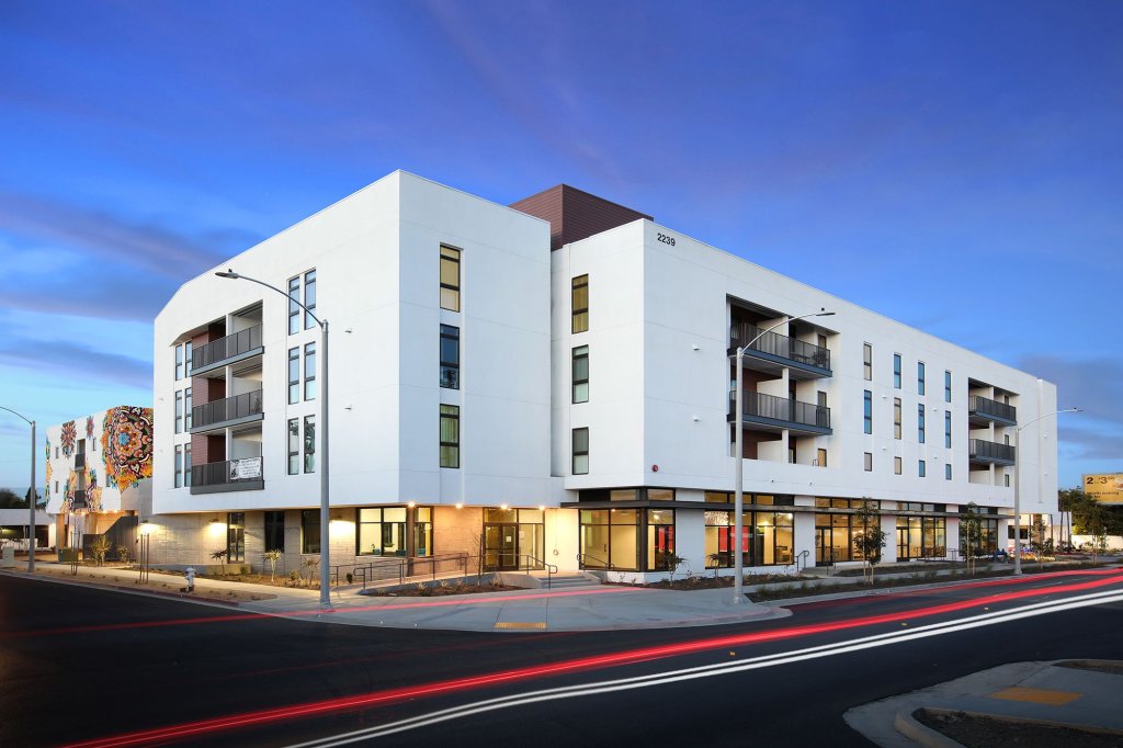 A before and after image shows a strip mall and parking lot before, and a multi-story apartment building after.