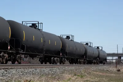 Train with black oil tankers.
