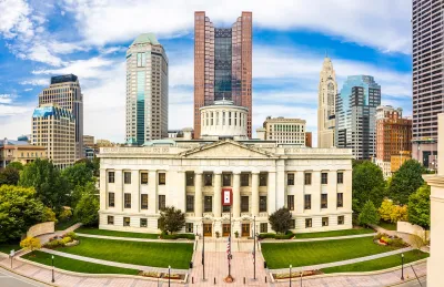 Ohio State Senate building nwith modern downtown Columbus skyscrapers in background.