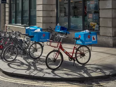 Domino's Pizza delivery bikes parked on a sidewalk in London, UK.