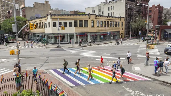 Pedestrians crossing a rainbow painted crosswalk in New York City.