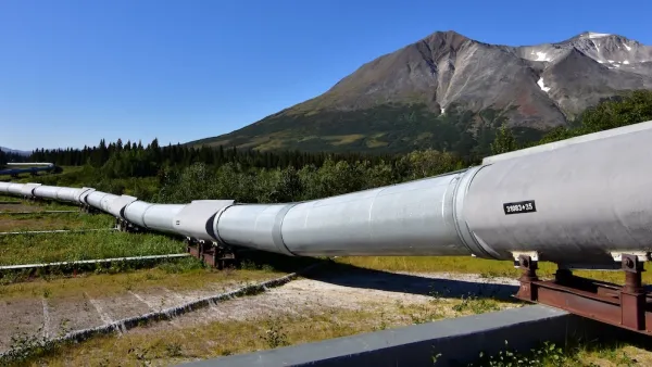 Ground level view of Alaska Pipeline oil pipeline near Prudhoe Bay, Alaska with bare mountains in background.