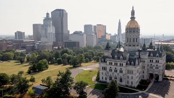Connecticut state capitol with gold dome and modern office buildings in background in Hartford, CT.