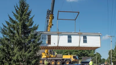 Modular home being lifted with crane.