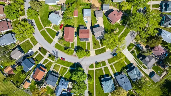 Bird's eye view of half-circle suburban street with large homes.
